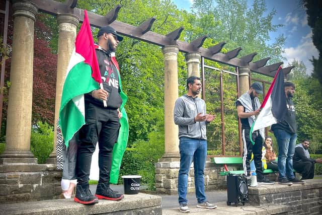 Local protestors bearing the Palestinian flag gather at Thompson Park in Burnley