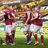 Chris Wood of Burnley celebrates with team mates after scoring their side's third goal and his hat trick during the Premier League match between Wolverhampton Wanderers and Burnley at Molineux on April 25, 2021 in Wolverhampton, England.