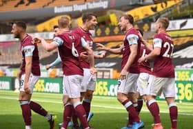 Chris Wood of Burnley celebrates with team mates after scoring their side's third goal and his hat trick during the Premier League match between Wolverhampton Wanderers and Burnley at Molineux on April 25, 2021 in Wolverhampton, England.