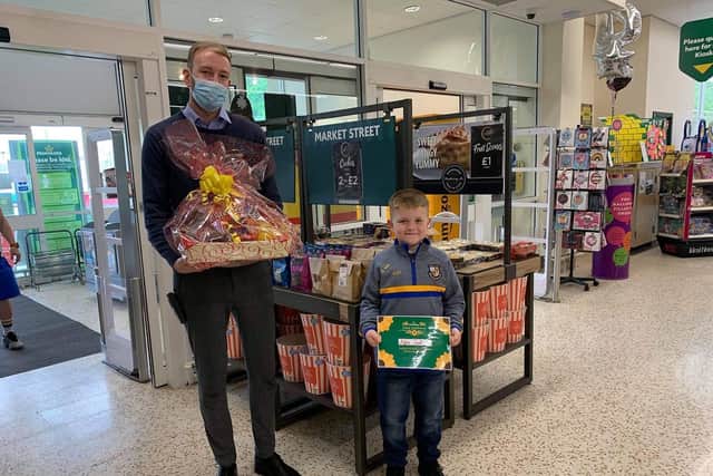 Alfie receives his award at Morrisons store in Todmorden from operations manager James