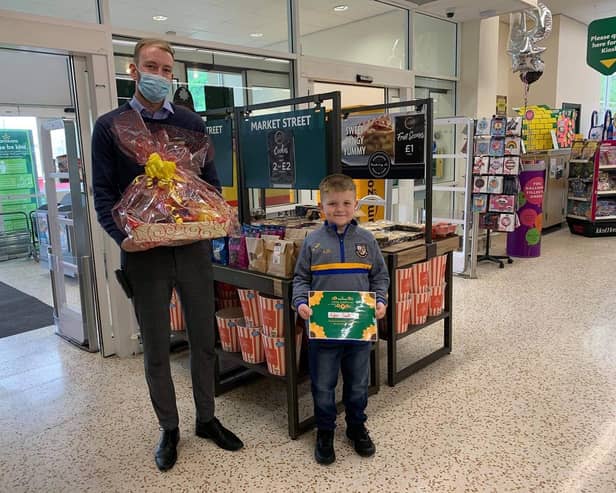 Alfie receives his award at Morrisons store in Todmorden from operations manager James