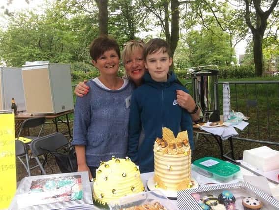 Cake stall holders Lindsey Dyer (left) and Mary Potter serve customer Robbie Dixon at the Buzzin' Bee Day held in Ightenhill Park in May, 2019