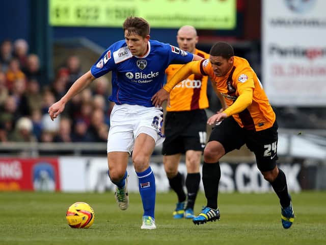 James Tarkowski of Oldham Athletic holds off Nathan Doyle of Bradford City during the Sky Bet League One match between Oldham Athletic and Bradford City at Boundary Park on December 01, 2013 in Oldham, England.