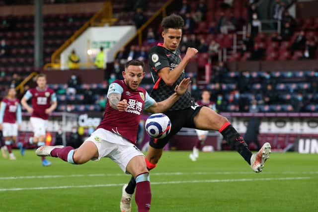 Josh Brownhill of Burnley shoots whilst under pressure from Rhys Williams of Liverpool during the Premier League match between Burnley and Liverpool at Turf Moor on May 19, 2021 in Burnley, England.