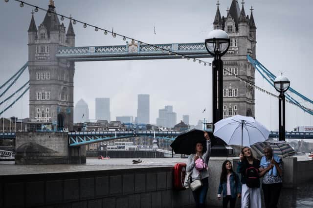 Three women and a girl walk in the rain in front of London's Tower Bridge on Tuesday, July 27, 2021 (Picture: Michael Holmes for JPIMedia)