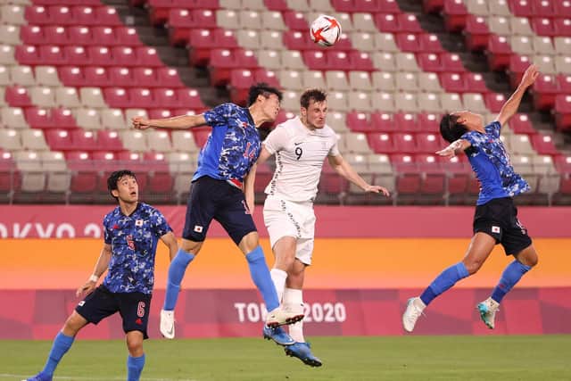 Chris Wood #9 of Team New Zealand competes for a header with Takehiro Tomiyasu #14 of Team Japan during the Men's Quarter Final match between Japan and New Zealand on day eight of the Tokyo 2020 Olympic Games at Kashima Stadium on July 31, 2021 in Kashima, Ibaraki, Japan.