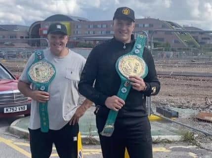 Tyson Fury with dad John and the two belts he will be donating as part of the fundraiser. Photo: Instagram @gypsyking101