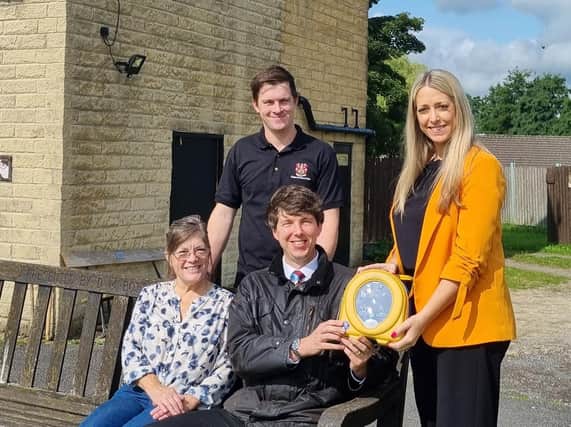 Charlotte Pickup, marketing manager for the Barnfield Group handing over the defibrillator to Jonathan Nixon, acting vice chairman of the cricket club, Gina Kegg (the club secretary) and cricketer Martin Kegg.