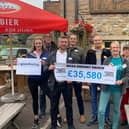 Matthew Stuttard and David Edmondson, of Glendinning Insurance Brokers, and Pendleside’s Christina Cope show off the amount raised by the MEGA Raisathon, along with other supporters