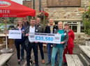 Matthew Stuttard and David Edmondson, of Glendinning Insurance Brokers, and Pendleside’s Christina Cope show off the amount raised by the MEGA Raisathon, along with other supporters