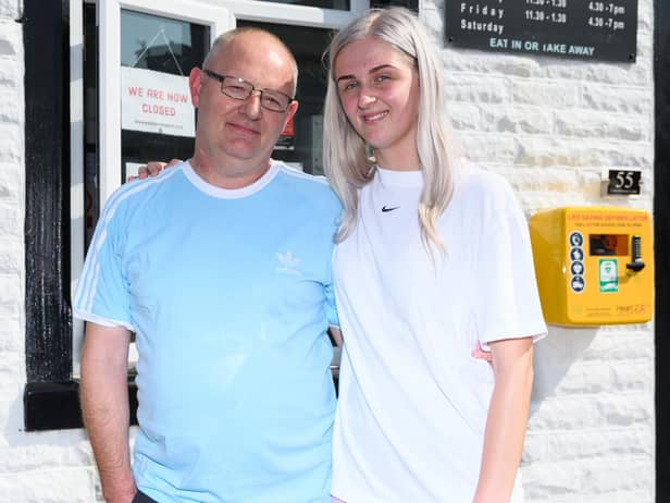 Jodie, pictured next to the defibrillator she raised the money for,  with her dad Michael who has paid tribute to his daughter for saving his life when he had a cardiac arrest