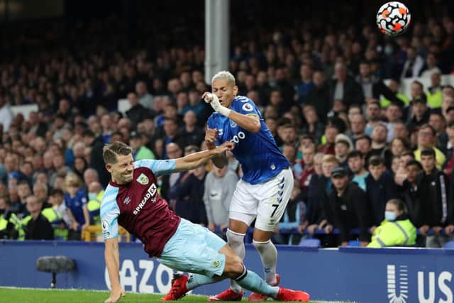 Richarlison of Everton is challenged by James Tarkowski of Burnley during the Premier League match between Everton and Burnley at Goodison Park on September 13, 2021 in Liverpool, England.