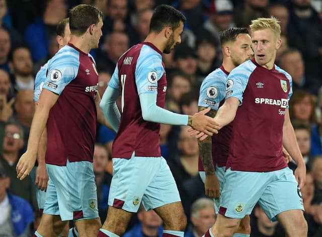 Burnley's English defender Ben Mee (R) celebrates with teammates after scoring the opening goal of the English Premier League football match between Everton and Burnley at Goodison Park in Liverpool, north west England on September 13, 2021.