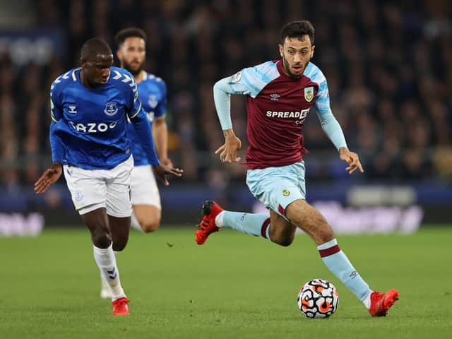 Dwight McNeil of Burnley is put under pressure by Abdoulaye Doucoure of Everton during the Premier League match between Everton and Burnley at Goodison Park on September 13, 2021 in Liverpool, England.