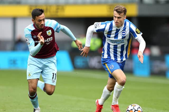 Solly March of Brighton and Hove Albion runs with the ball whilst under pressure from Dwight McNeil of Burnley during the Premier League match between Burnley and Brighton & Hove Albion at Turf Moor on August 14, 2021 in Burnley, England.
