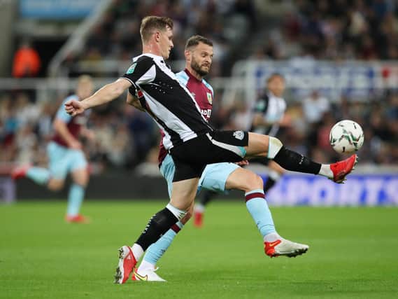 Emil Krafth of Newcastle United clears the ball under pressure from Erik Pieters of Burnley during the Carabao Cup Second Round match between Newcastle United and Burnley at St. James Park on August 25, 2021 in Newcastle upon Tyne, England.