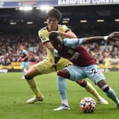 Maxwel Cornet of Burnley holds off Takehiro Tomiyasu of Arsenal during the Premier League match between Burnley and Arsenal at Turf Moor on September 18, 2021 in Burnley, England.