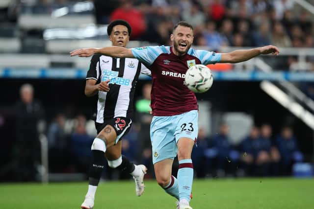 Erik Pieters of Burnley shields the ball from Jamal Lewis of Newcastle United during the Carabao Cup Second Round match between Newcastle United and Burnley at St. James Park on August 25, 2021 in Newcastle upon Tyne, England.