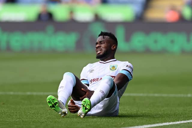 Maxwel Cornet of Burnley reacts as he appears to be injured during the Premier League match between Leicester City and Burnley at The King Power Stadium on September 25, 2021 in Leicester, England.