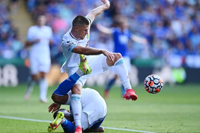 Johann Gudmundsson of Burnley is challenged by Ryan Bertrand of Leicester City during the Premier League match between Leicester City and Burnley at The King Power Stadium on September 25, 2021 in Leicester, England.