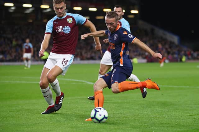 Edin Visca of Istanbul Basaksehir shoots as Ben Gibson of Burnley challenges during the UEFA Europa League third round qualifier second leg between Burnley and Istanbul Basaksehir at Turf Moor on August 16, 2018 in Burnley, England.