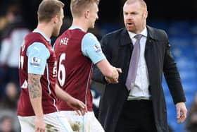 Burnley's English manager Sean Dyche (R) celebrates at the end of the match with goal scorer English defender Ben Mee (2nd L) during the English Premier League football match between Chelsea and Burnley at Stamford Bridge in London on February 21, 2015.
