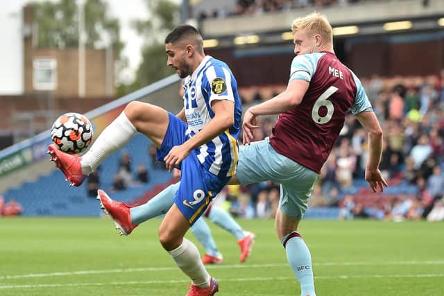 Neal Maupay of Brighton and Hove Albion controls the ball whilst under pressure from Ben Mee of Burnley during the Premier League match between Burnley and Brighton & Hove Albion at Turf Moor on August 14, 2021 in Burnley, England.