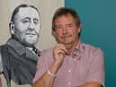 Dave Thomas next to an image of former Burnley FC chairman Bob Lord who was one of the few people to recognise the contribution player Jimmy Hogan made to the sporting world.
