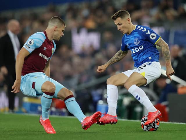Lucas Digne of Everton is put under pressure by Johann Gudmundsson of Burnley during the Premier League match between Everton and Burnley at Goodison Park on September 13, 2021 in Liverpool, England.