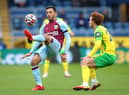 Dwight McNeil of Burnley controls the ball ahead of Josh Sargent of Norwich City during the Premier League match between Burnley and Norwich City at Turf Moor on October 02, 2021 in Burnley, England.