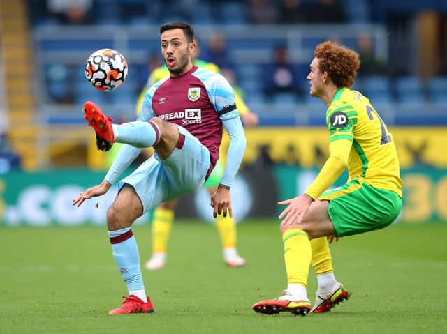 Dwight McNeil of Burnley controls the ball ahead of Josh Sargent of Norwich City during the Premier League match between Burnley and Norwich City at Turf Moor on October 02, 2021 in Burnley, England.