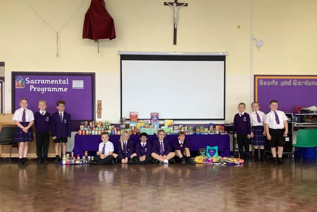 Students at St Mary Magdalene's RC Primary School in Burnley with some of the donations for their harvest festival