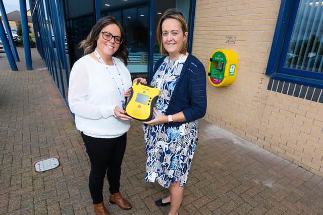 Katy Cain (right) and Kerry Kelly with the defibrillator which Alcidion, the company they work for, donated to Business First in Burnley
