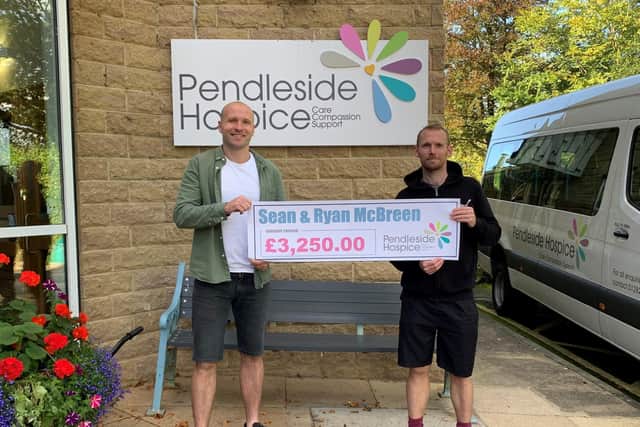 Sean (left) and Ryan presenting a cheque at Pendleside Hospice for the money they raised completing a run of the Leeds Liverpool Canal in five days