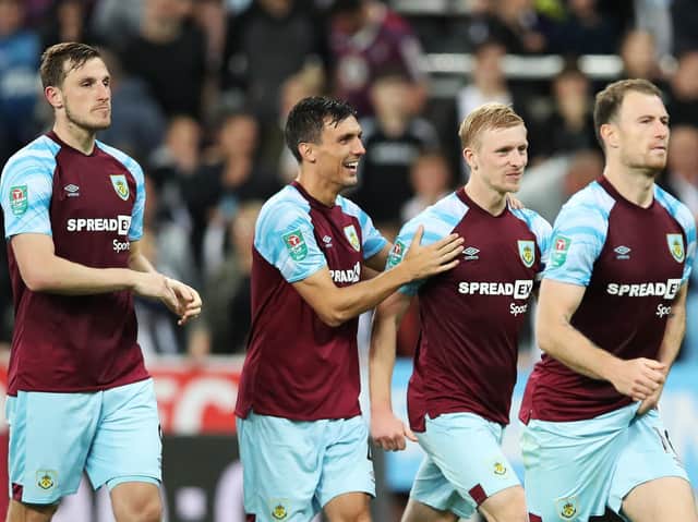 Jack Cork and Ben Mee of Burnley celebrates after Charlie Taylor scores the winning penalty in the shootout during the Carabao Cup Second Round match between Newcastle United and Burnley at St. James Park on August 25, 2021 in Newcastle upon Tyne, England.