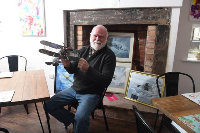 Sam Markland pictured with a model plane and pictures inside the Toll Bar Cottage cafe   Photo: Neil Cross