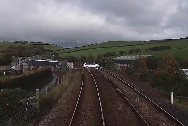 A still image from a Network Rail video showing a driver taking their life in their hands by jumping red lights at a level crossing in Cumbria.