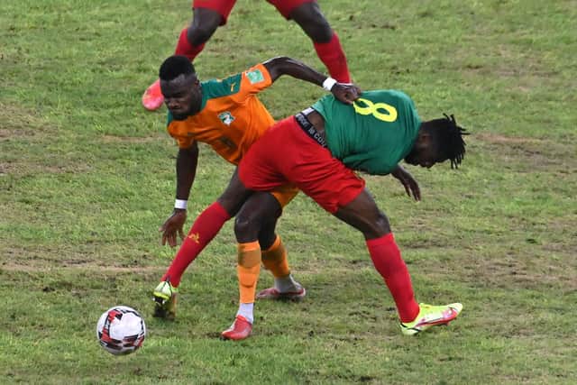 Ivory Coast's Cornet Maxwel (L) fights for the ball with Cameroon's Andre Anguissa (8) during the FIFA Qatar 2022 World Cup qualification football match between Ivory Coast and Cameroon at the Alassane Ouattara Ebimpe stadium Anyama on September 6, 2021.