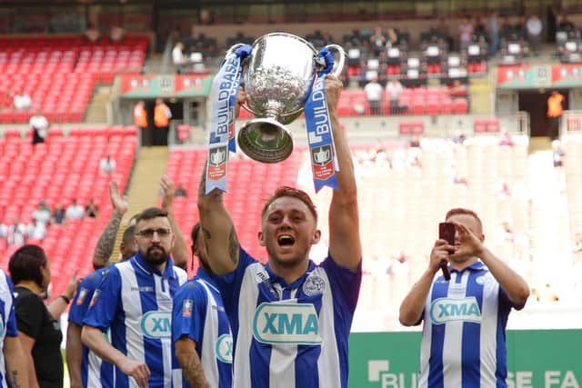 Lewis Brownhill of Thatcham Town lifts the Trophy after winning the Buildbase FA Vase Final between Stockton Town and Thatcham Town at Wembley Stadium on May 20, 2018 in London, England.