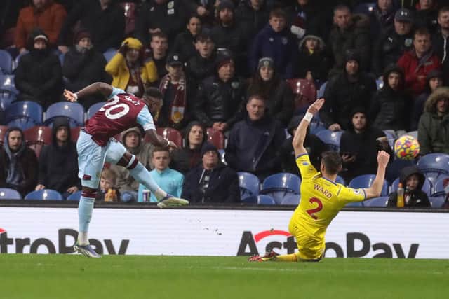 Maxwel Cornet of Burnley scores their team's third goal past Joel Ward of Crystal Palace during the Premier League match between Burnley and Crystal Palace at Turf Moor on November 20, 2021 in Burnley, England.