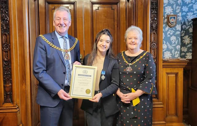 Lamissah proudly shows her Medal of Honour she won at the British Citizen Youth Awards to the Mayor and Mayoress of Burnley Coun. Mark Townsend and his wife Kerry