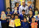 Nick Waldron with some of the pupils and the books he donated to their school in Accrington.