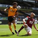 Adama Traore of Wolverhampton Wanderers is challenged by Charlie Taylor of Burnley during the Premier League match between Wolverhampton Wanderers and Burnley at Molineux on April 25, 2021 in Wolverhampton, England.