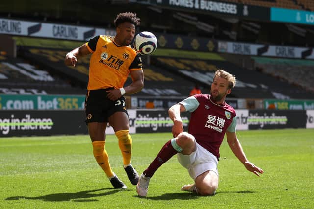 Adama Traore of Wolverhampton Wanderers is challenged by Charlie Taylor of Burnley during the Premier League match between Wolverhampton Wanderers and Burnley at Molineux on April 25, 2021 in Wolverhampton, England.