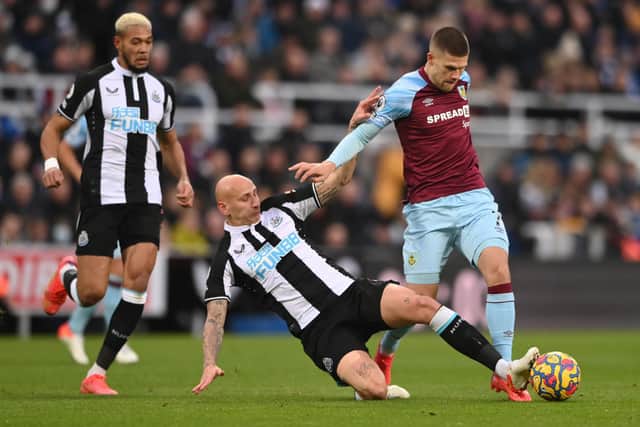 Newcastle player Jonjo Shelvey fouls Burnley player Johann Gudmundsson during the Premier League match between Newcastle United and Burnley at St. James Park on December 04, 2021 in Newcastle upon Tyne, England.