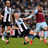 Johann Gudmundsson of Burnley is tackled by Jonjo Shelvey of Newcastle United during the Premier League match between Newcastle United and Burnley at St. James Park on December 04, 2021 in Newcastle upon Tyne, England.