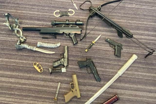 Police seized drugs, a knuckle duster, four BB guns, an air rifle, knives, swords, a crossbow and more than £1,000 cash during today's raids.