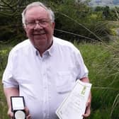 Peter Pike, a former long serving MP for Burnley who died yesterday at the age of 84, with the medal he received for helping to found the homeless charity Emmaus.