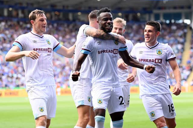 Maxwel Cornet of Burnley celebrates with team mates after scoring their side's second goal during the Premier League match between Leicester City and Burnley at The King Power Stadium on September 25, 2021 in Leicester, England.