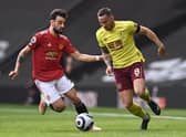 Josh Brownhill of Burnley is challenged by Bruno Fernandes during the Premier League match between Manchester United and Burnley at Old Trafford on April 18, 2021 in Manchester, England.